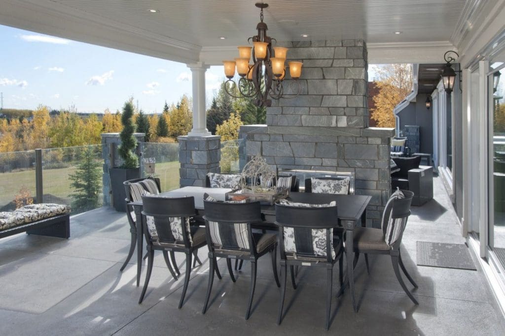 Exteriro fireplace on balcony with covered table and stunning view of the valley