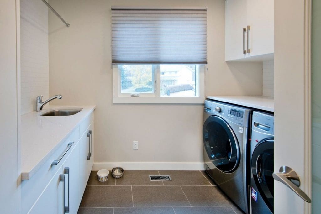 Canyon Meadows Project By Renova Homes & Renovations Calgary, Alberta full side by side laundry with custom cabinets and sink