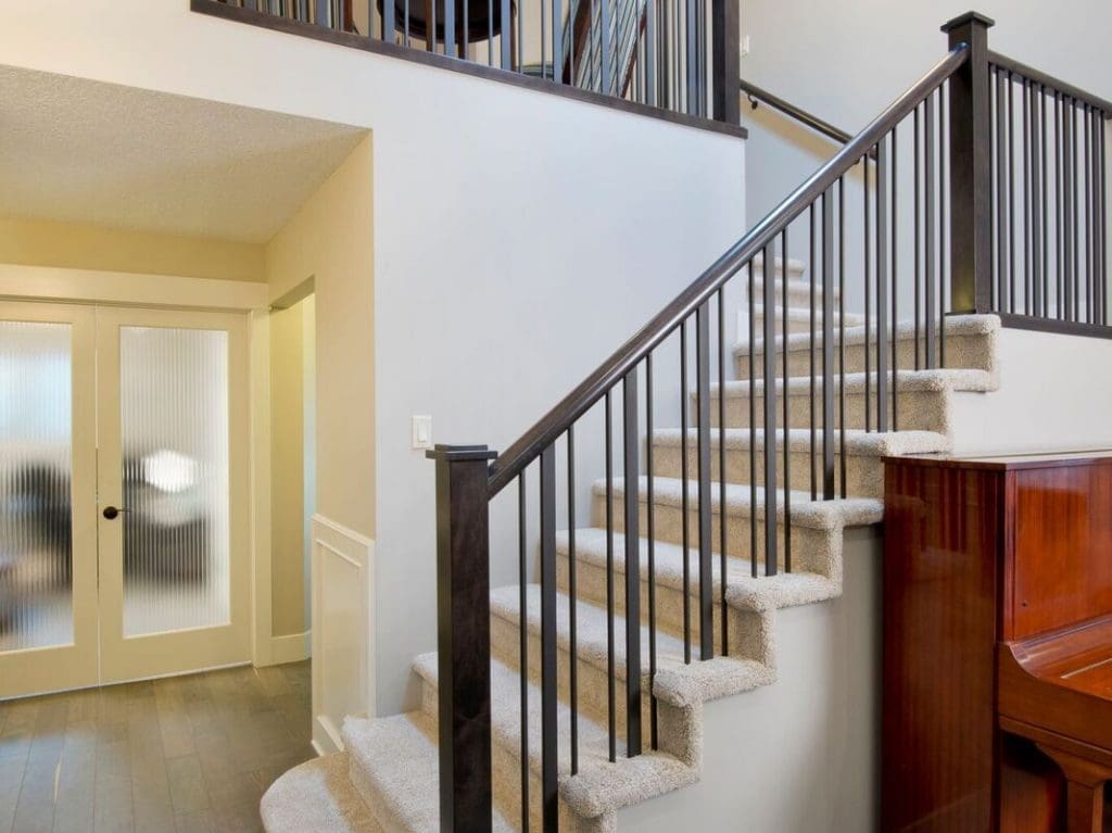 Edgemont Project custom wood railings with mixed metals leading to a spacious living room By Renova Homes & Renovations Calgary, Alberta