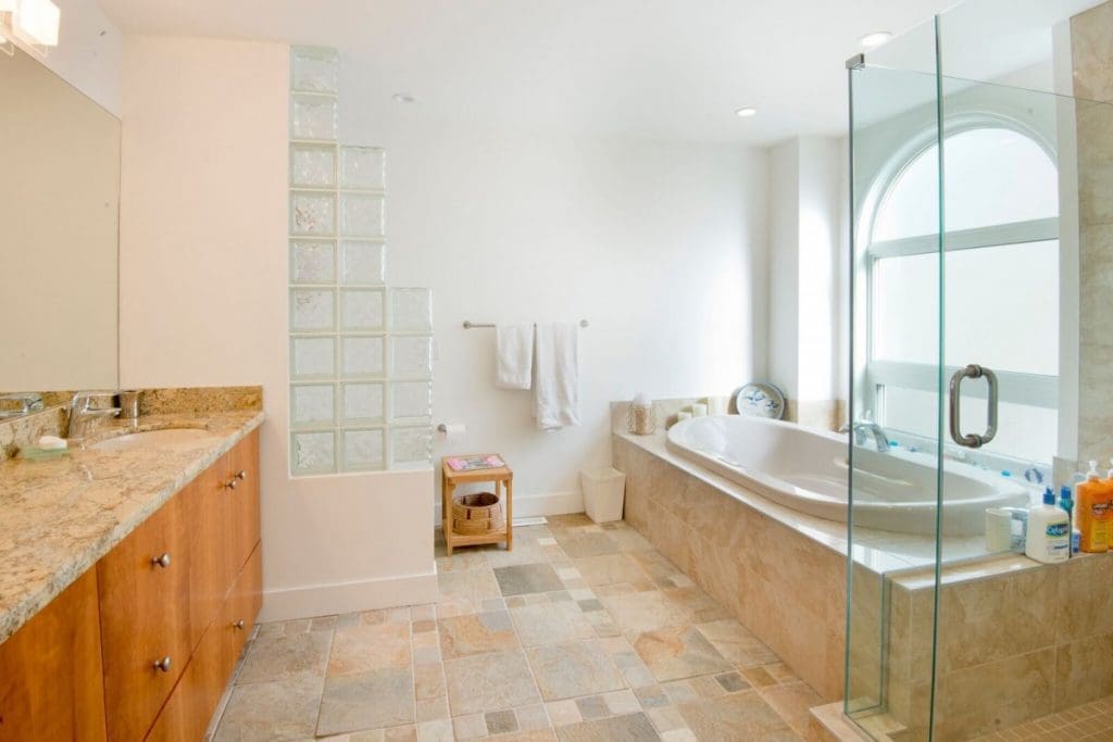 Hawkwood Renovation By Renova Homes & Renovations Calgary, Alberta master bedroom ensuite with sunken soaker bathtub perched below a grans arched window