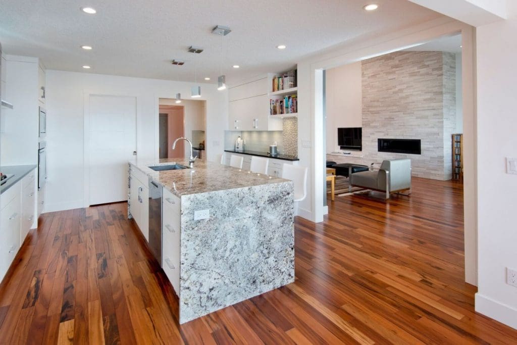 Hawkwood home with custom full marble island with red wood hardwood and white cabinets