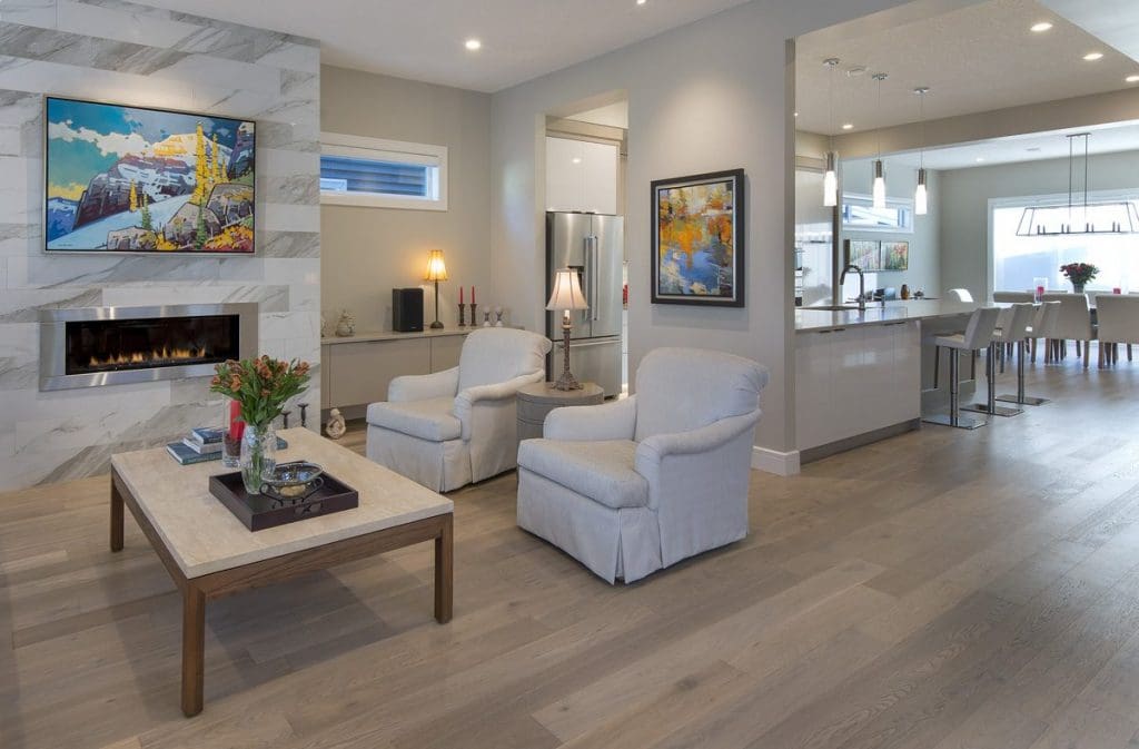 Southwest Calgary Custom Home Project By Renova Homes & Renovations Calgary, Alberta living room with tiled fireplace and great real wood hardwood expanding into the kitchen and dining area