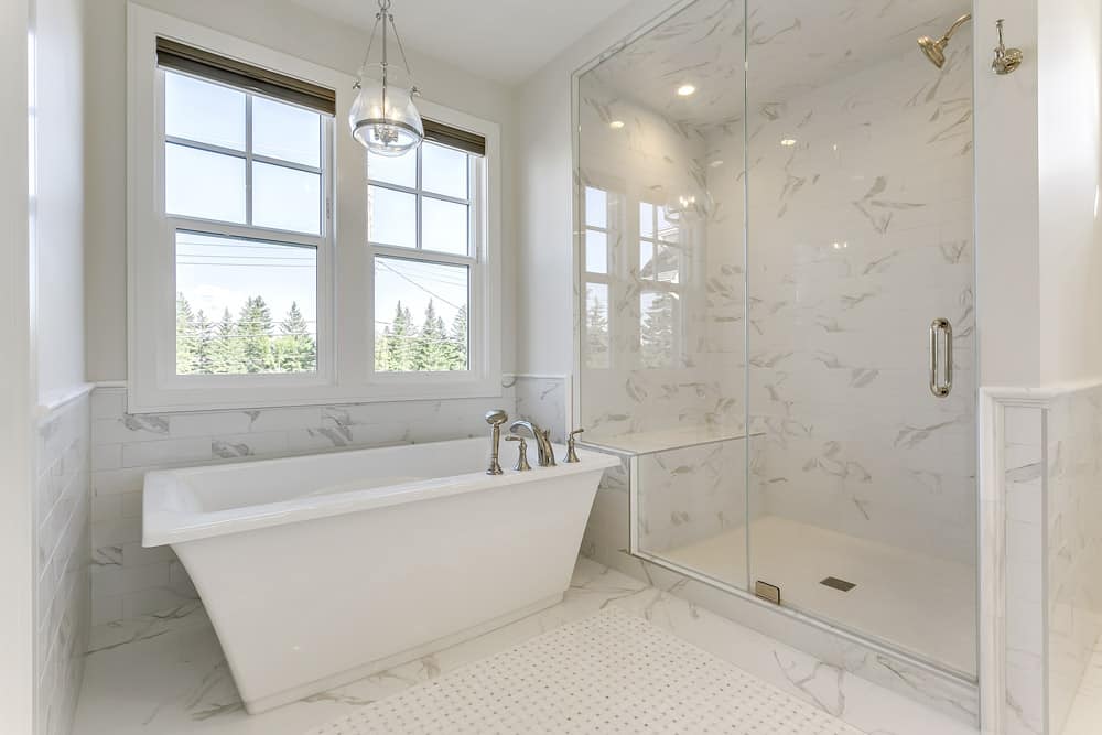 Mount Royal Custom Home master bedroom ensuite stand alone bathub with a marble tile shower By Renova Homes & Renovations Calgary, Alberta