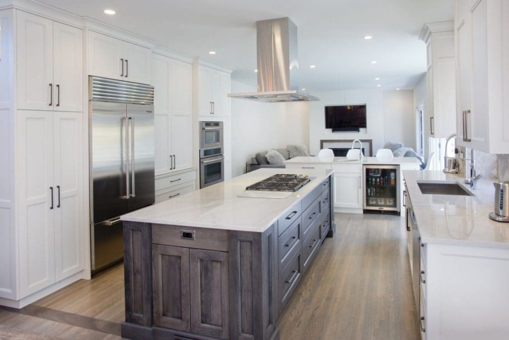 Canyon Meadows Project By Renova Homes & Renovations Calgary, Alberta with custom cabinetry and kitchen island with a floating hoodfan