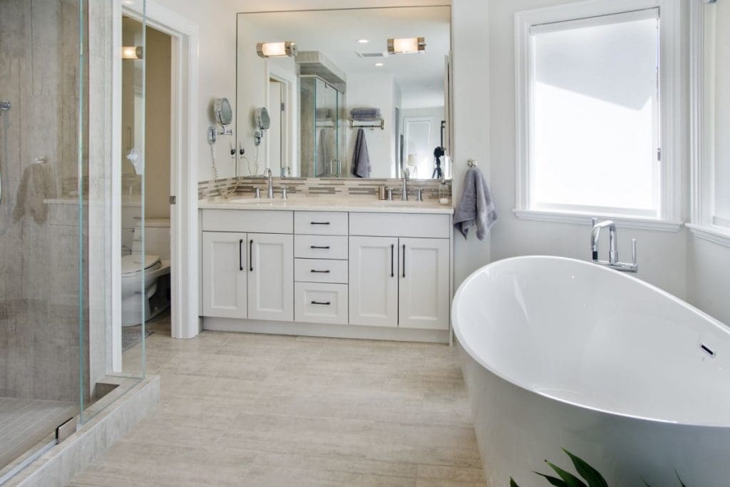 Patterson Interior Project By Renova Homes & Renovations Calgary, Alberta full soaker tub and tiled shower with a jack and jill vanity