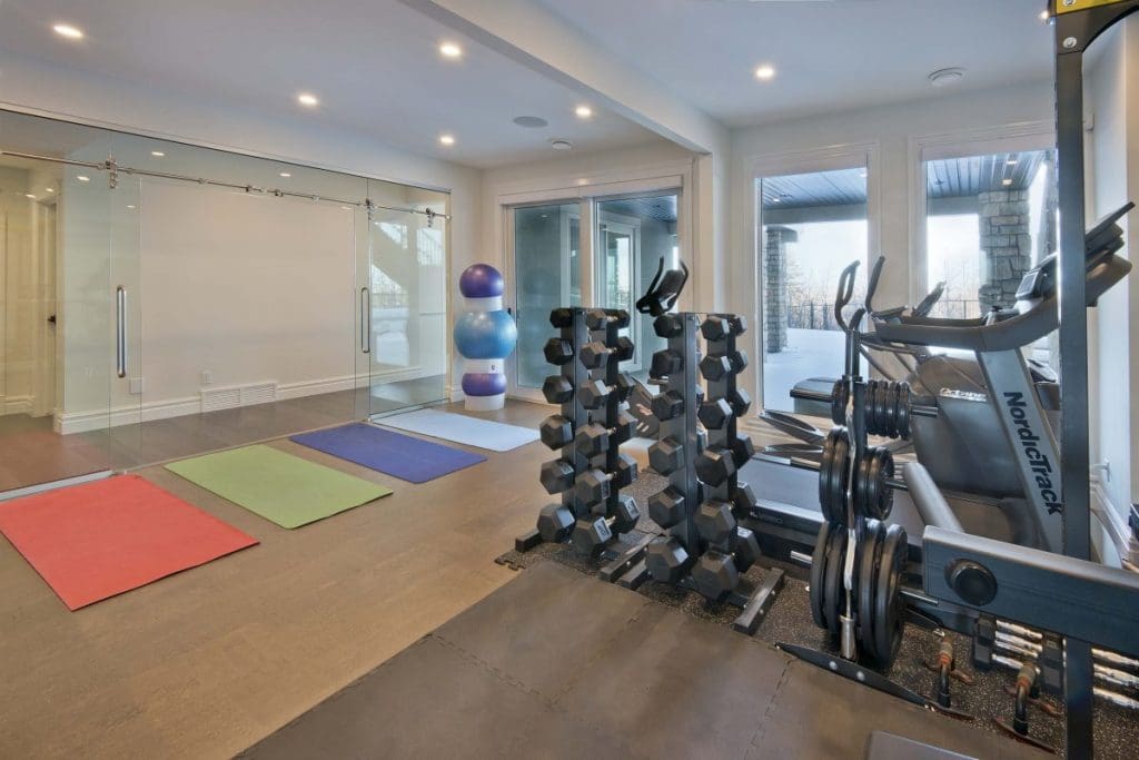 Southwest Calgary Custom Home By Renova Homes & Renovations Calgary, Alberta home gym with a full glass sliding door and cork floors