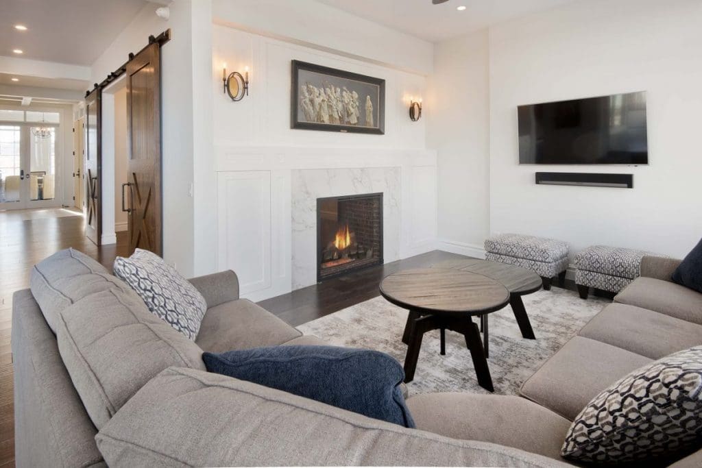 Southwest Calgary Custom Home By Renova Homes & Renovations Calgary, Alberta with a stunning marble fireplace and wrap around sectional ready for comfort