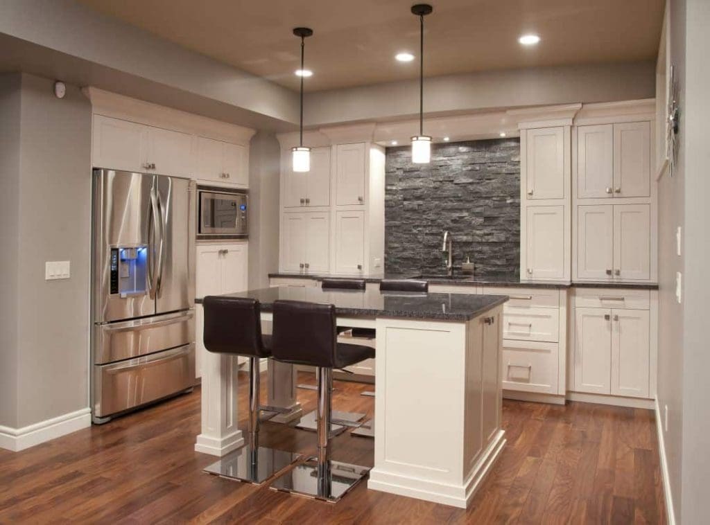 Wentworth Project By Renova Homes & Renovations In Calgary, Alberta Kitchen with white cabinets and stone work for backsplash