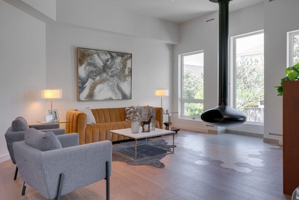 Arbour Lake Great Room with floating fireplace with a masculine leather ambiance by Renova Homes & Renovations In Calgary, Alberta